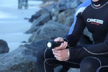 a scuba diver holding a dive light